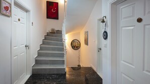 Eine Treppe mit Marmorboden, die zu einer Empfangshalle mit einer Tür führt.