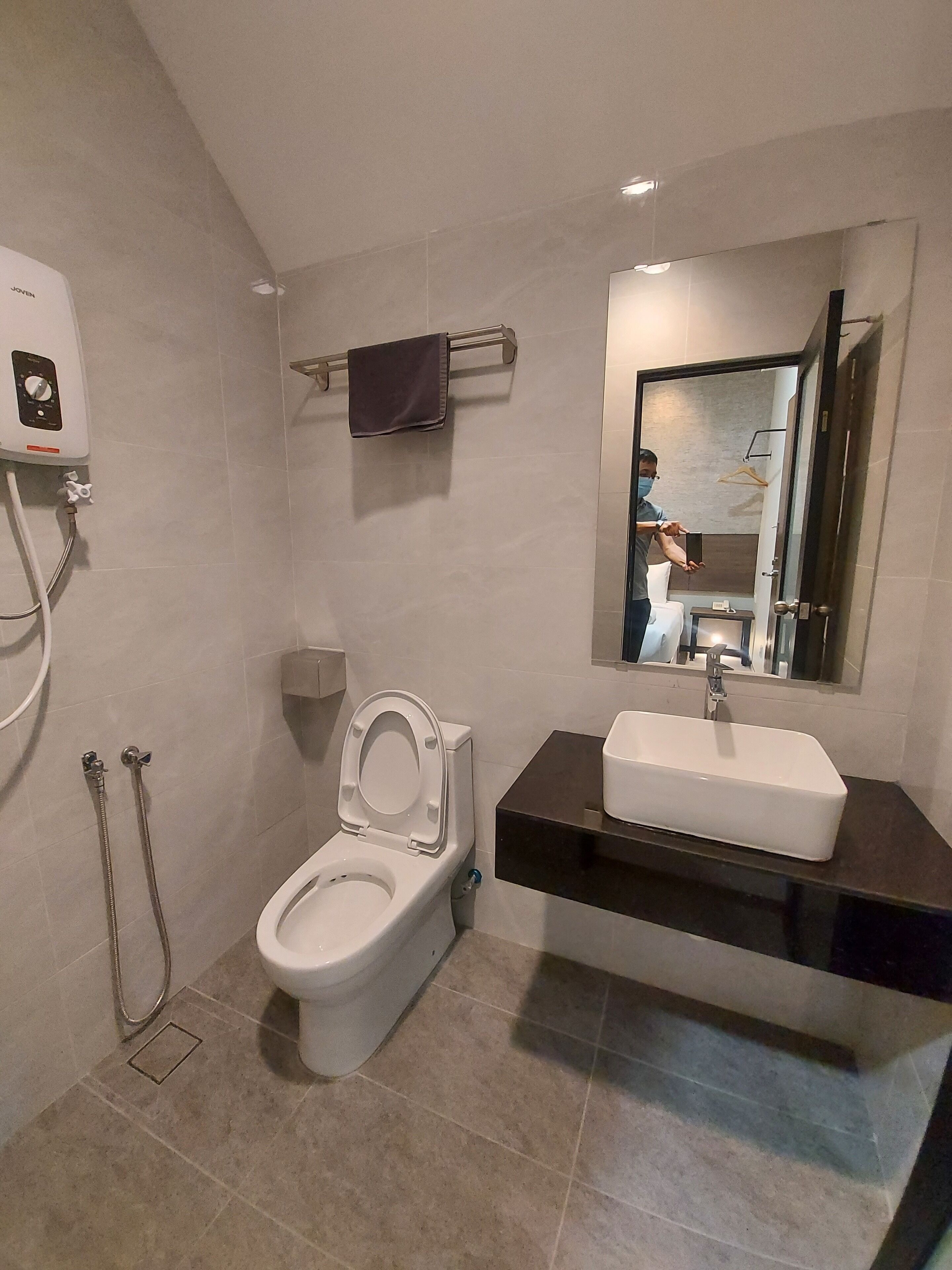 Un baño moderno con inodoro, lavamanos y ducha.