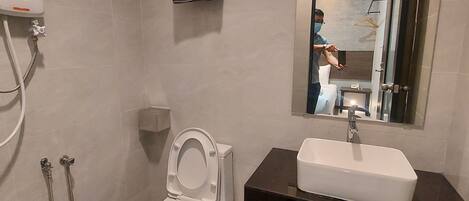 Un baño moderno con inodoro, lavamanos y ducha.
