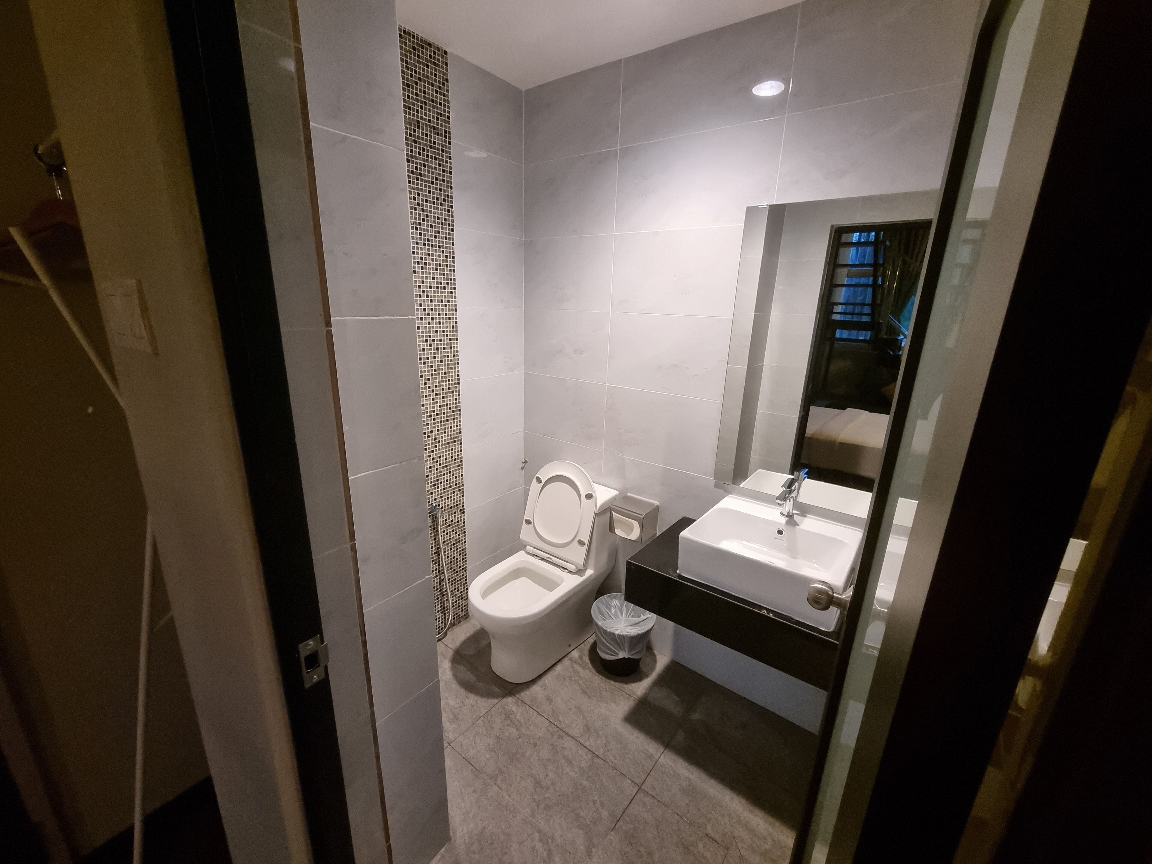 A modern bathroom with a toilet, sink, and shower area.
