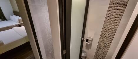 Un baño moderno con puerta de cristal, inodoro y zona de ducha.