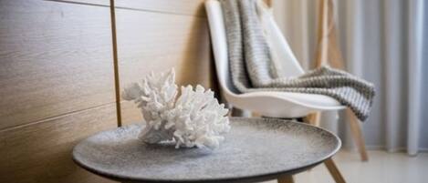 A modern room with a round table, a white chair, and a textured wall.
