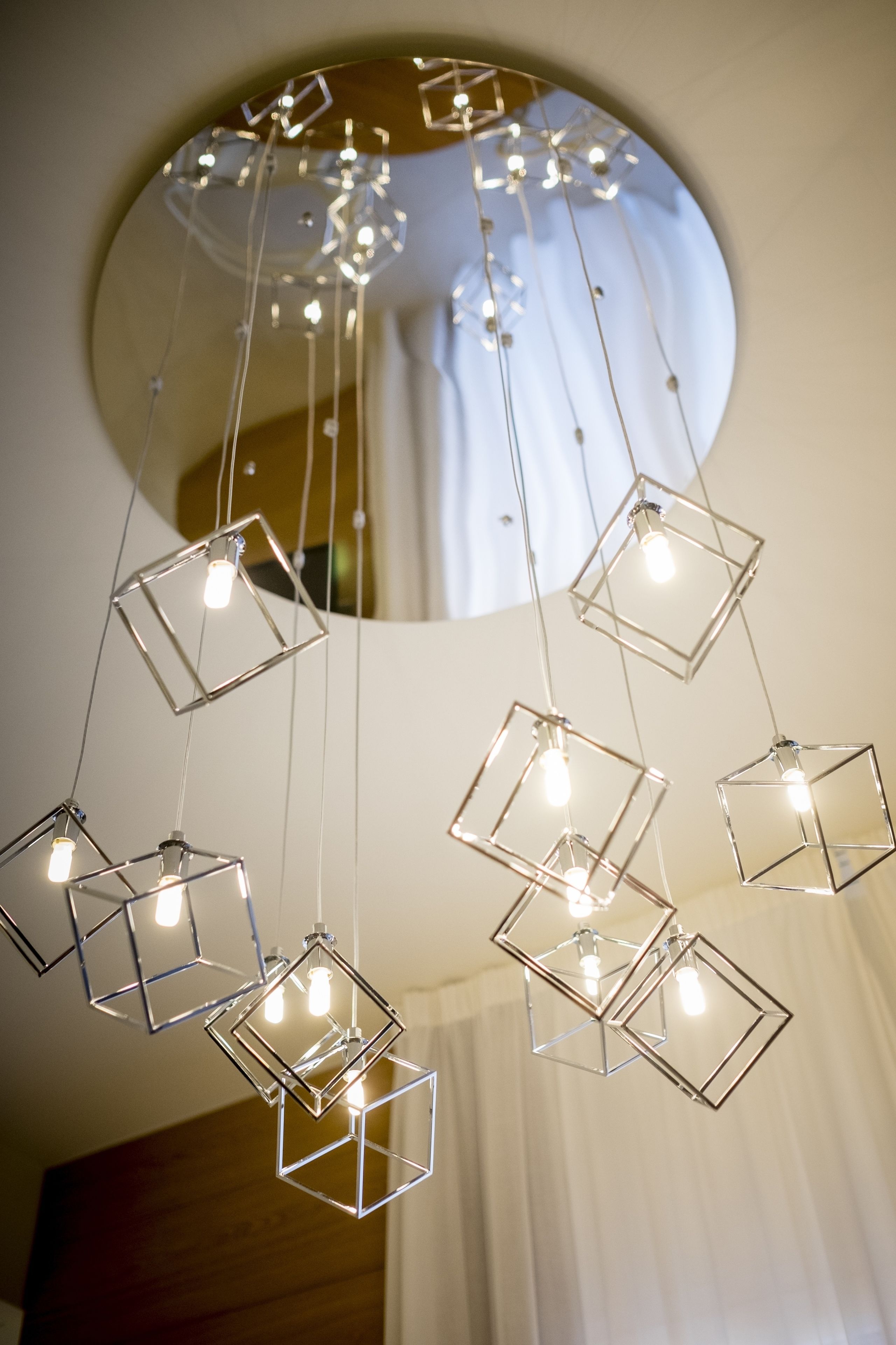 A modern chandelier with geometric shapes and hanging bulbs.