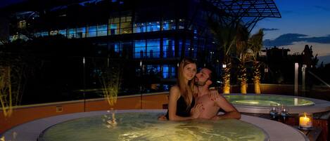 Ein Paar in einer Hot Tub vor einem modernen Gebäude.