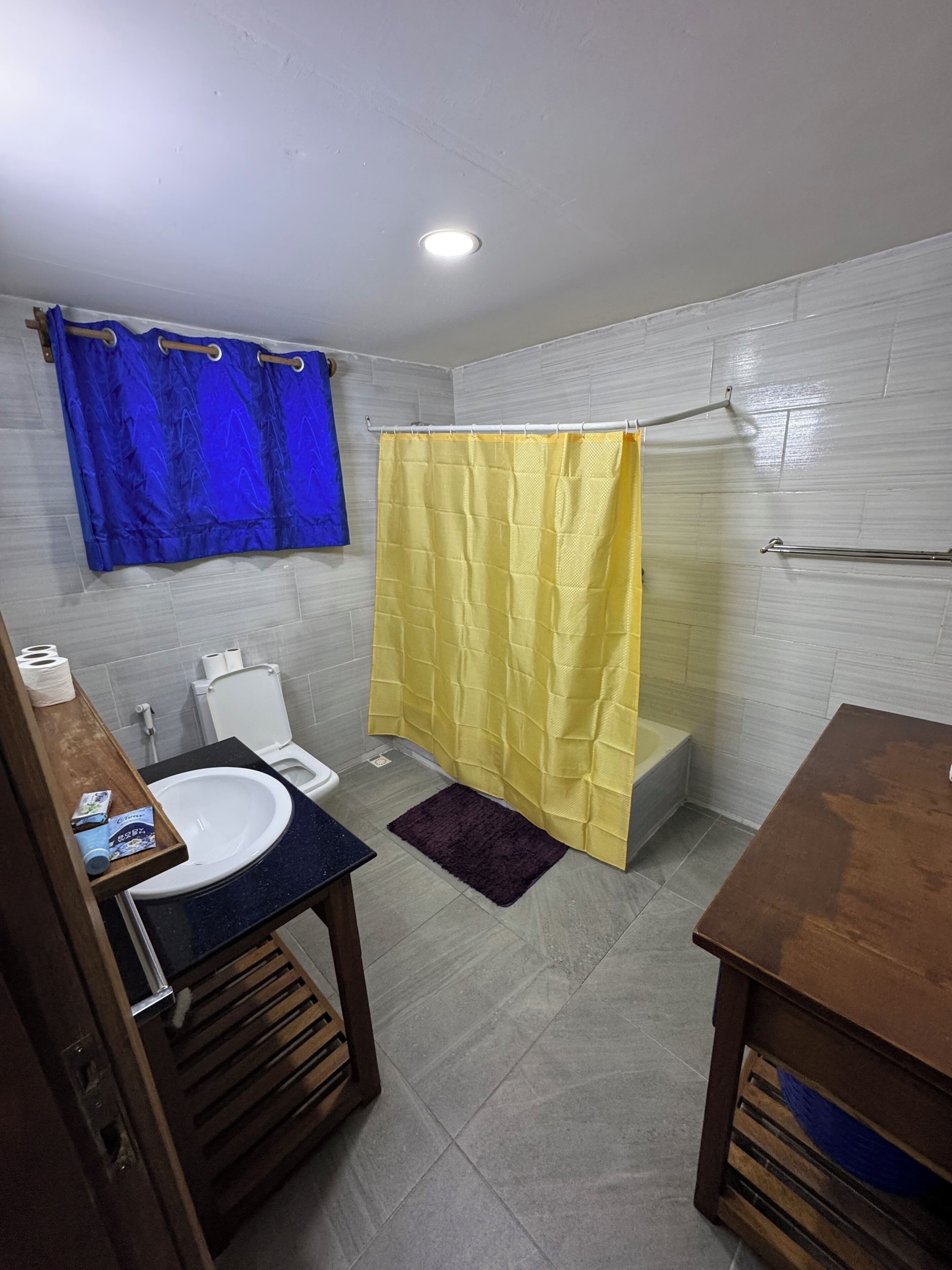 Ein Badezimmer mit Toilette, Waschbecken, Duschvorhang und Handtuchhalter.