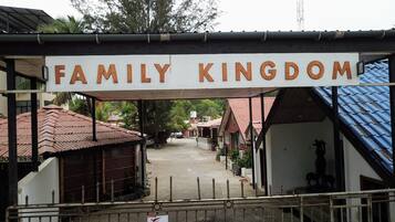 A sign reading "Family Kingdom" above a covered walkway leading to a building with a red roof.