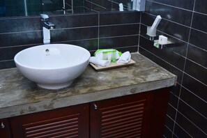 A bathroom with a large white sink, a wooden tray with toiletries, and a mirror above the sink. - Deluxe 4BR Penthouse By Unique Towers (Colombo)