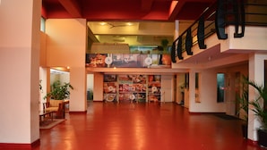 A spacious lobby with a red floor, a staircase, and a mural of a beach scene. - Deluxe 4BR Penthouse By Unique Towers (Colombo)