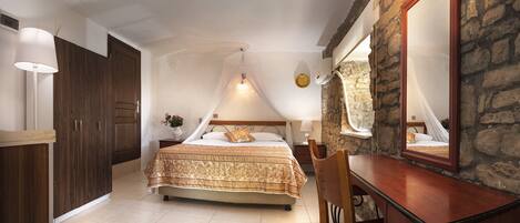 A bedroom with a bed, a nightstand, a mirror, and a wardrobe.