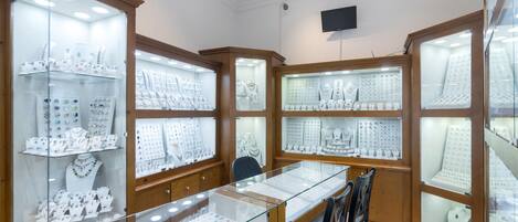 Een juwelier met glazen vitrines en houten kasten.