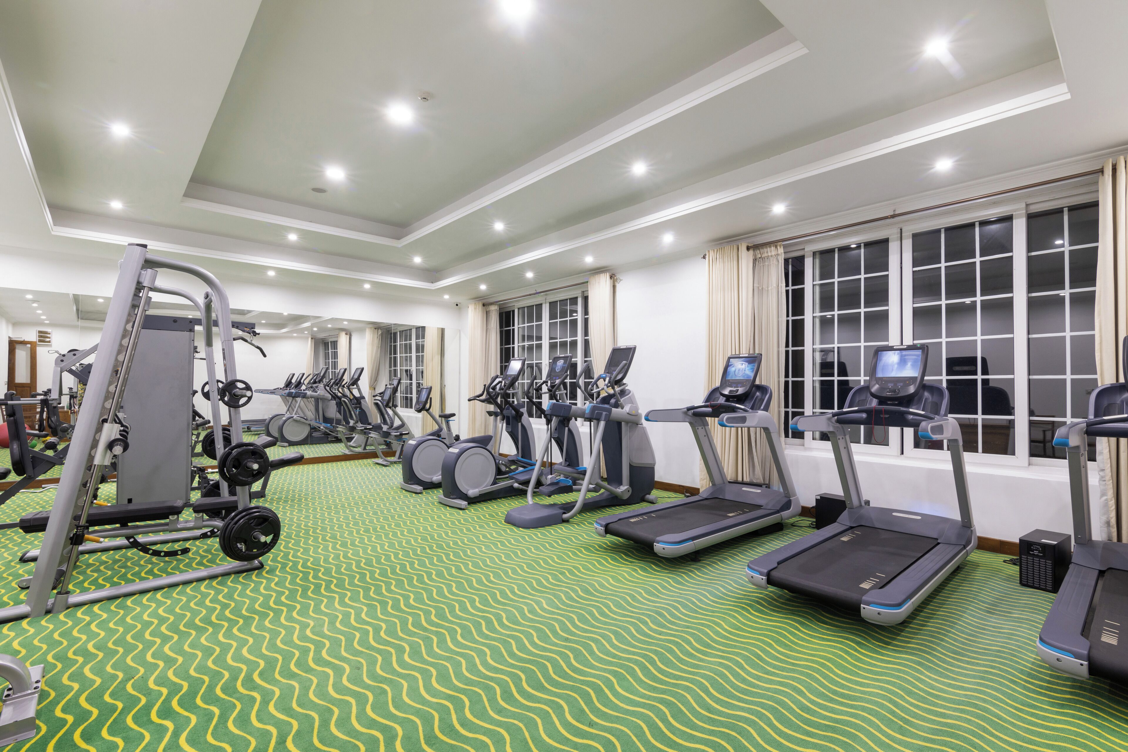 A gym with treadmills, elliptical machines, and weight equipment.