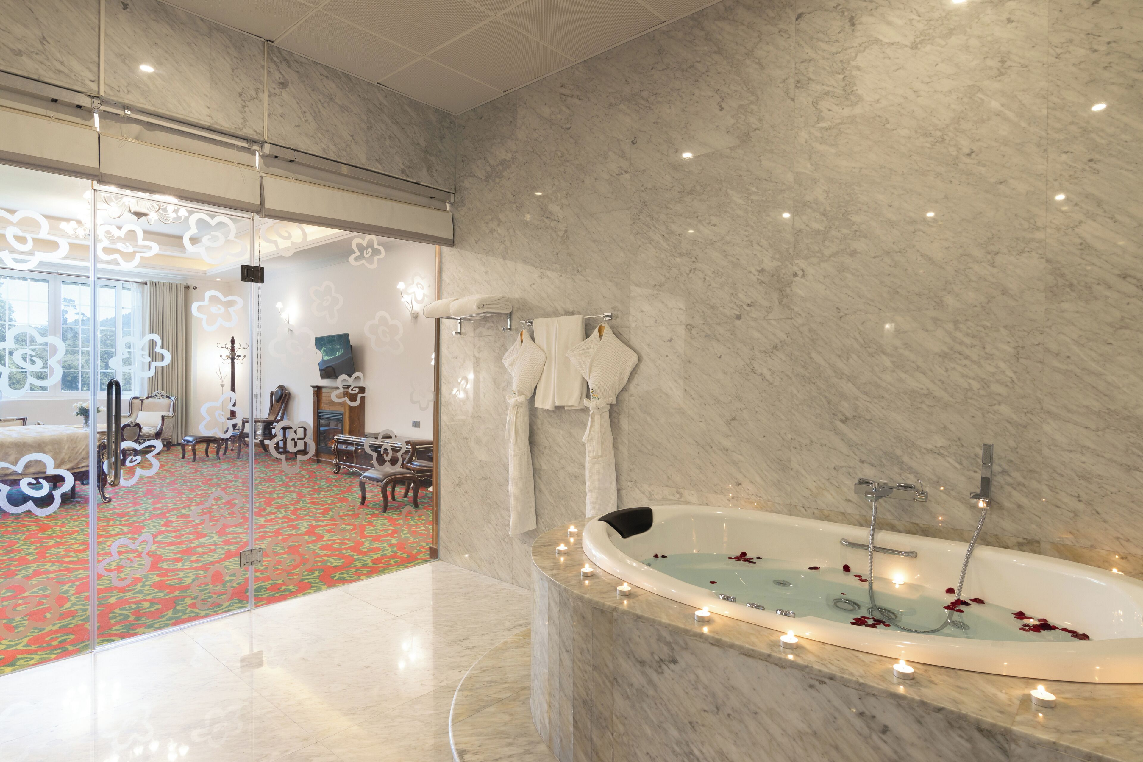 A modern bathroom with a marble floor, a freestanding bathtub, and a glass shower enclosure.