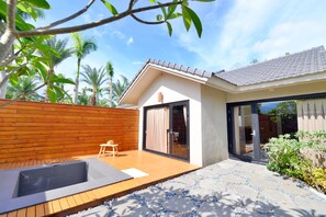 A modern house with a wooden deck, a hot tub, and a glass door leading to a patio. - Bear Forest Villa (Shoufeng)