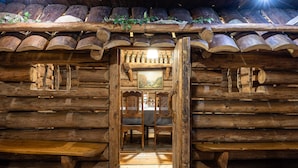 A log cabin interior with a dining area, wooden benches, and a table. - Hotel Marysin Dwór (Katowice)
