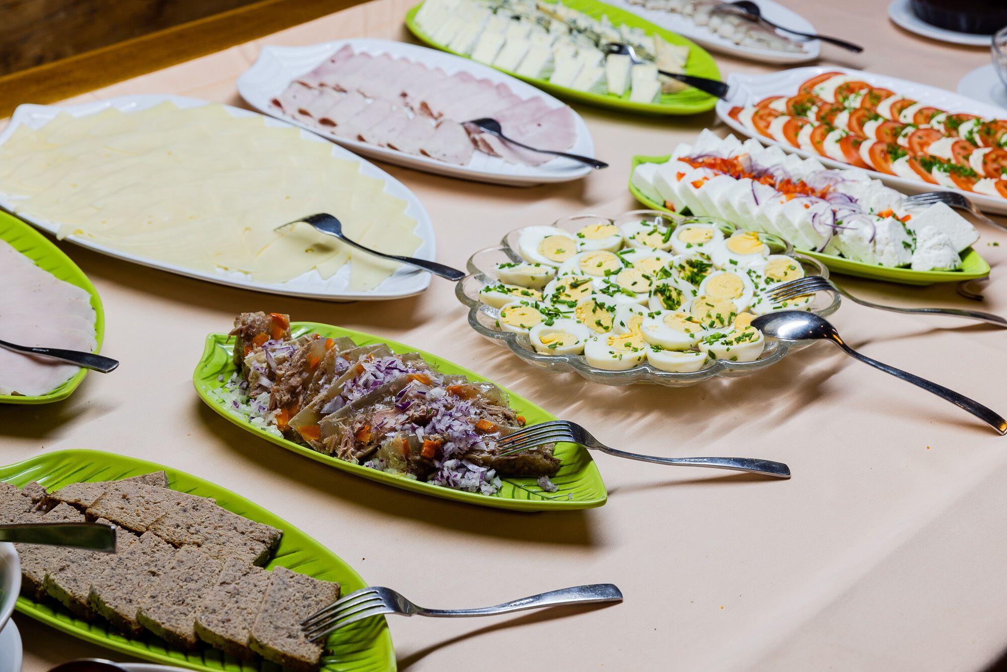 A buffet table with various dishes including sliced meats, salads, and other food items.