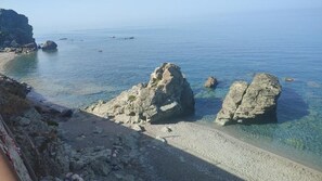 A coastal landscape with clear waters, rocky formations, and a sandy beach. - B&B Benvenuti al Sud (Aiello Calabro)