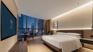 A modern hotel room with a large bed, a bench, a small table, and a city view through large windows. - Four Points by Sheraton Chongqing (Chongqing)