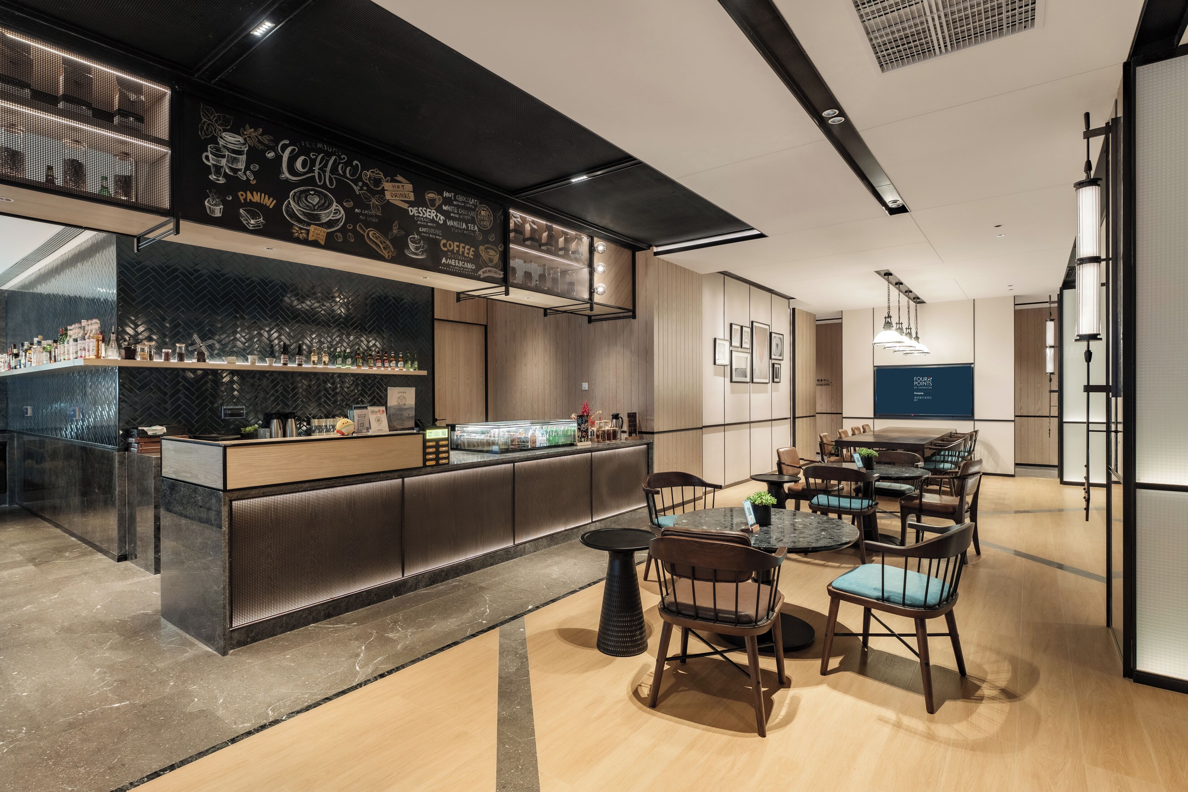 Un espace bar moderne avec un comptoir, des sièges et un tableau affichant le menu.