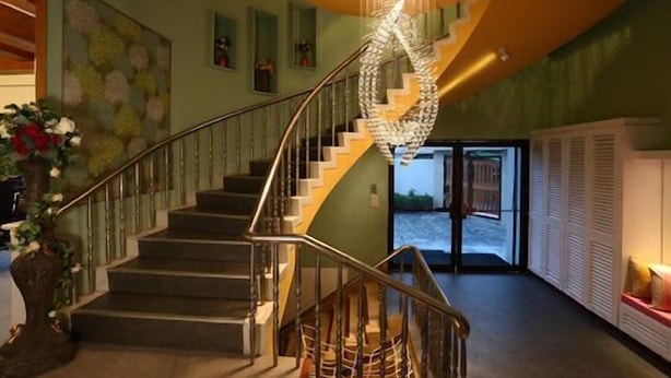 Un escalier à l’architecture en spirale originale, menant à une porte qui donne sur un plan d’eau.