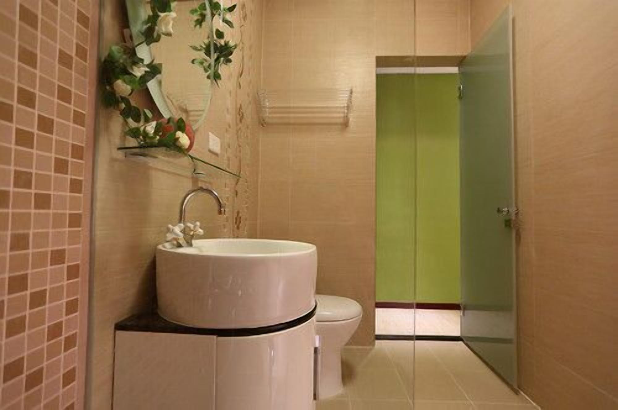 A bathroom with a sink, toilet, and a green door.