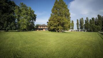 A large, open grassy area with a building in the background.