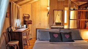 Een gezellige houten kamer met een bed, een bureau en een stoel.