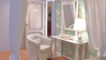 A room with a white armchair, a vanity with a mirror and a lamp, floral wallpaper, and a door labeled "3".