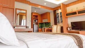 Une chambre d’hôtel comprenant un lit, une télévision, un coin cuisine et une salle de bain.