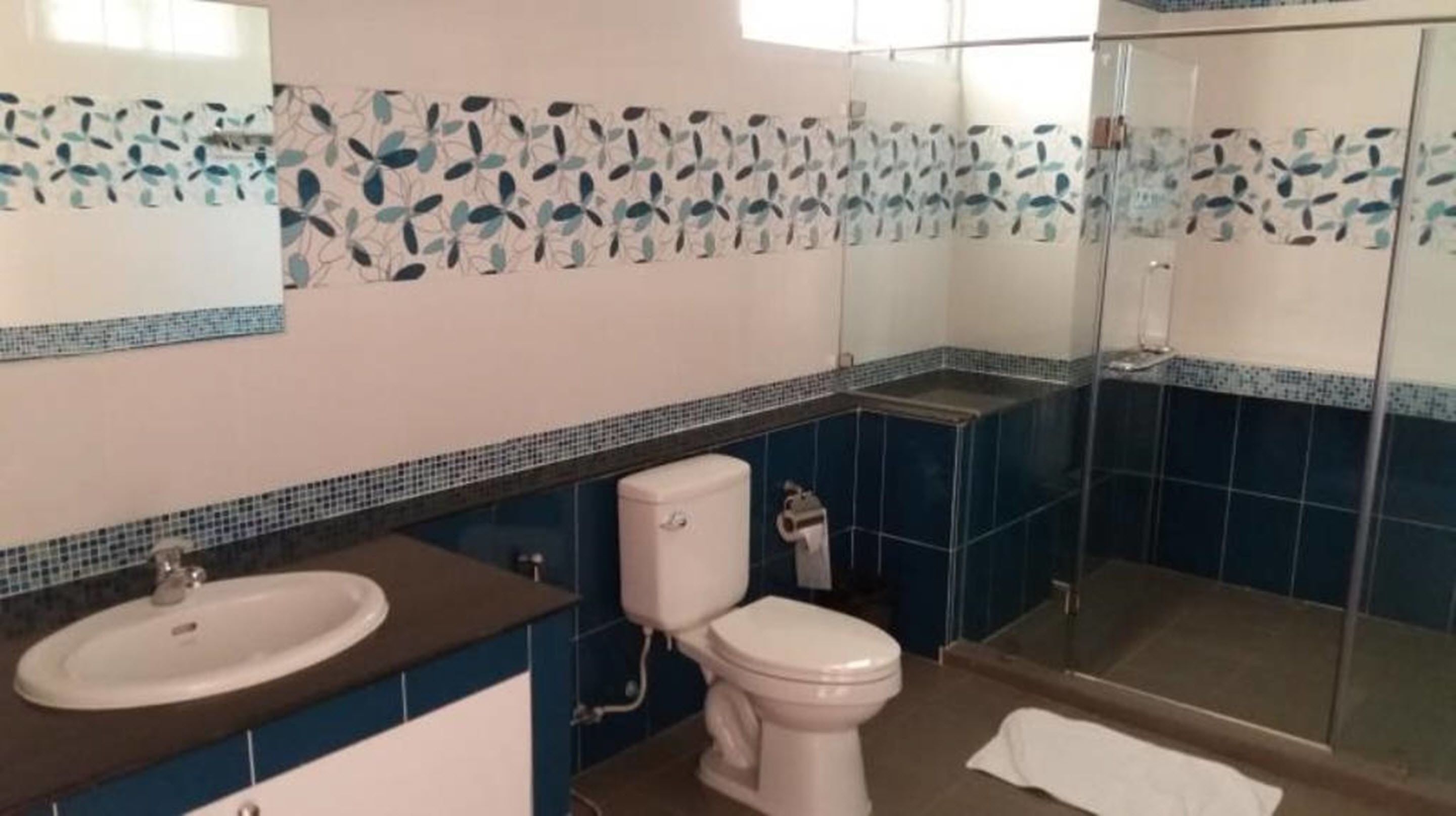 A bathroom with a sink, toilet, and shower.