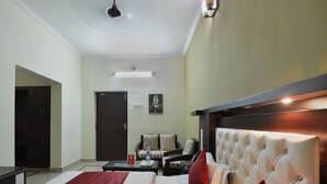 A hotel room with a bed, a desk, a chair, and a sofa. - OYO 7337 Sai Leela (Puri)