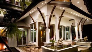A luxurious indoor pool area with a modern design, featuring a central water feature and seating areas.