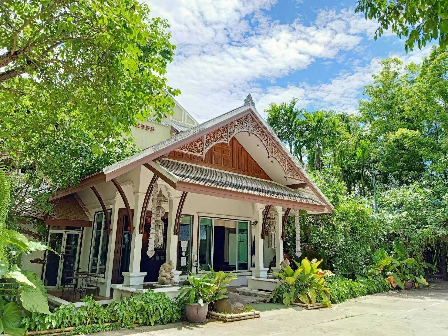 A traditional building with a covered porch, columns, and a staircase leading to the entrance.