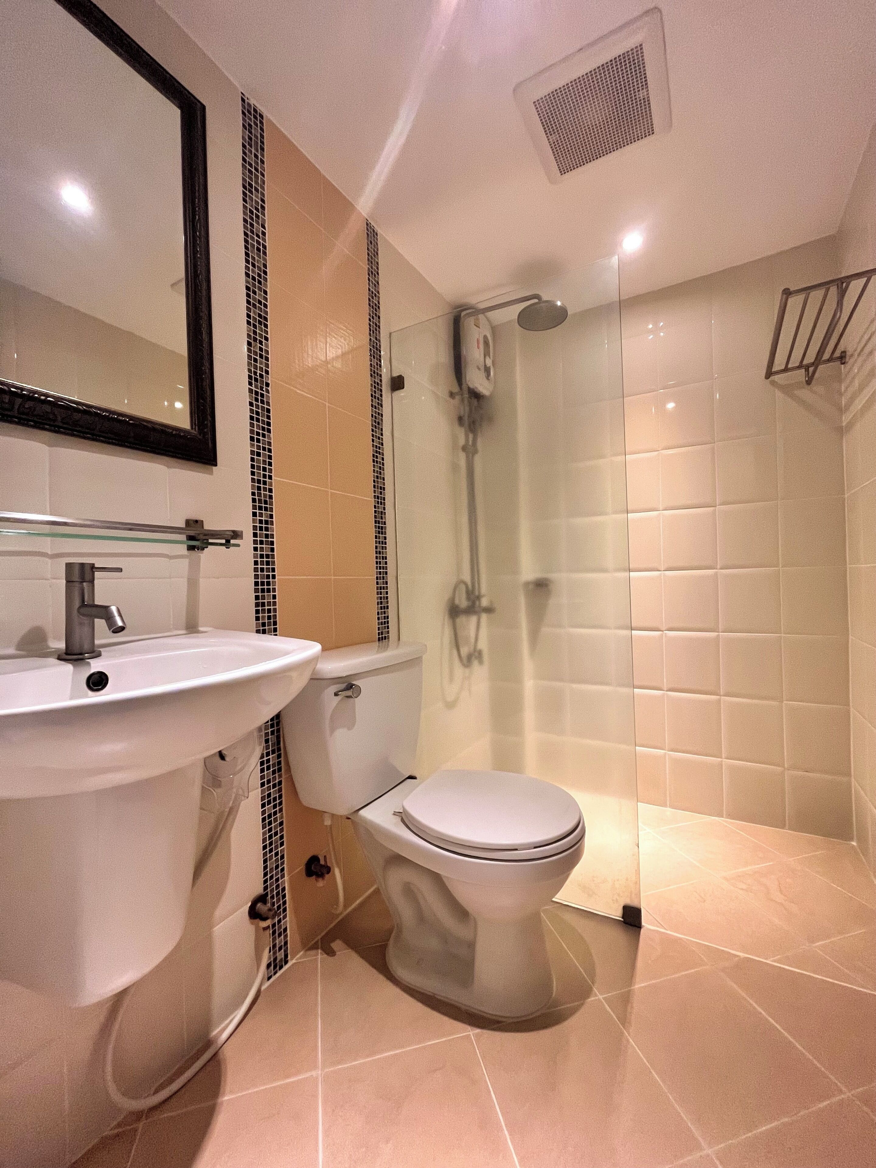 A bathroom with a sink, toilet, and shower.