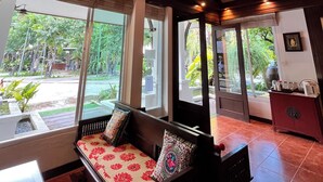 A room with a wooden bench, large windows, and hanging lanterns.