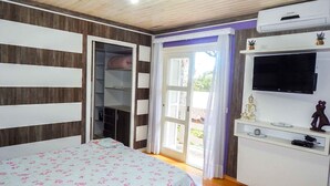 A bedroom with a bed, a wardrobe, a television, and an air conditioning unit. - Residencial Encantos da Natureza (Canela)