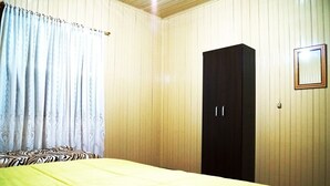 A room with a bed, a wardrobe, and a mirror on the wall. - Residencial Recanto do Sossego Gramado (Gramado)