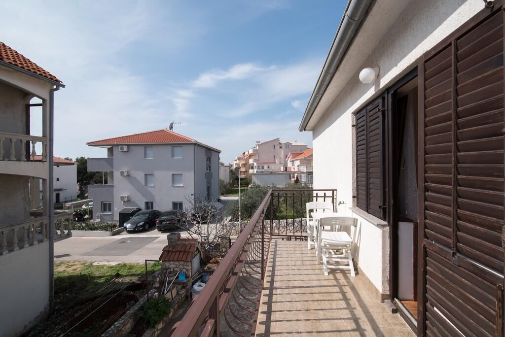 A residential area with a balcony, a garage door, and a parked car.
