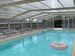 Una piscina al aire libre, sombrillas, tumbonas