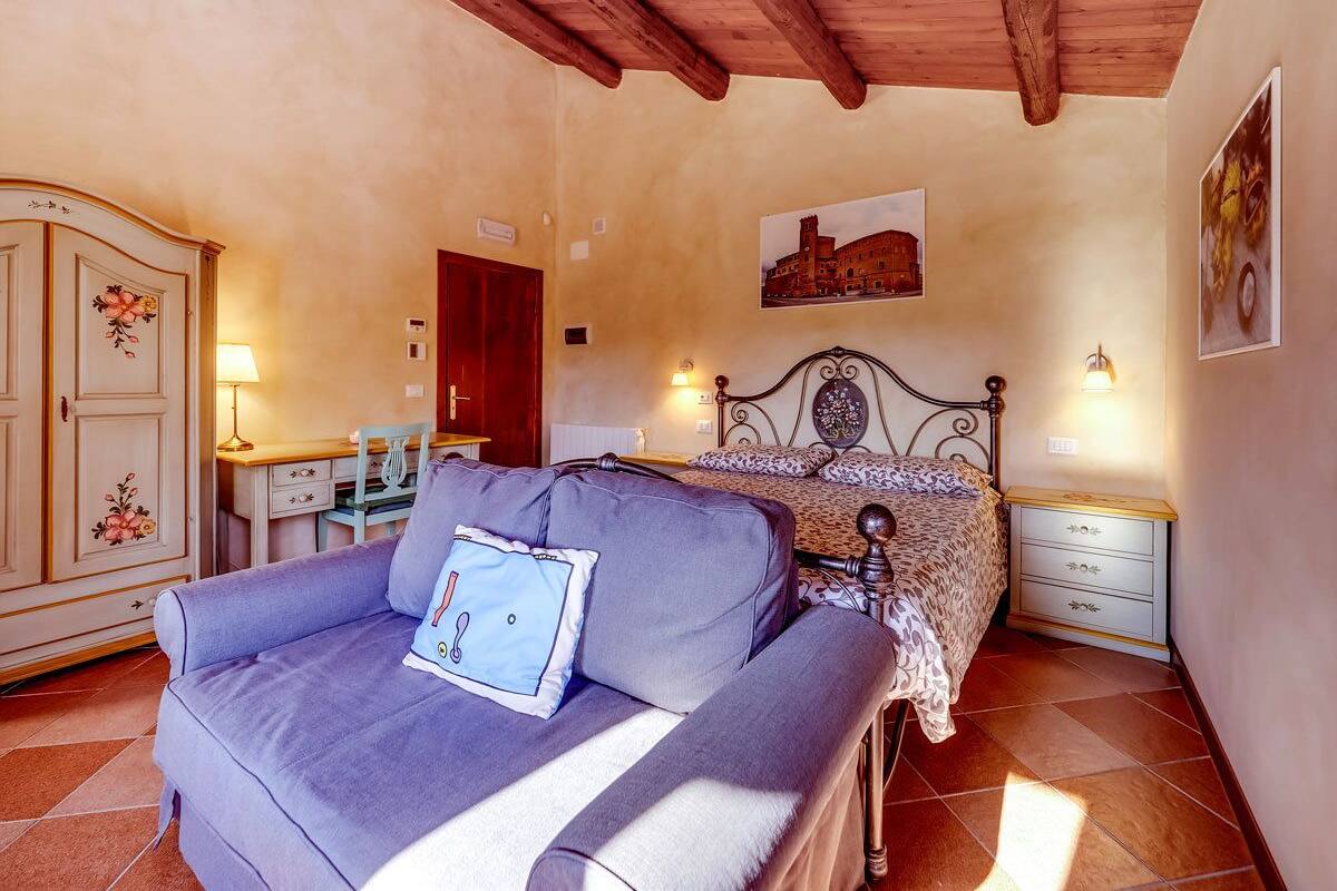 Une chambre à coucher avec un lit, un canapé, un bureau et une armoire.