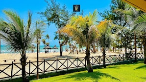 Una playa con palmeras, una valla y un cartel de Diego Flats.