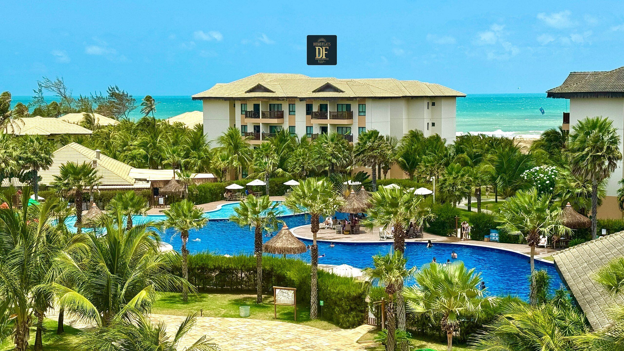 A resort with a pool, palm trees, and a building with a sign 'DEGLOFLATS DF'.