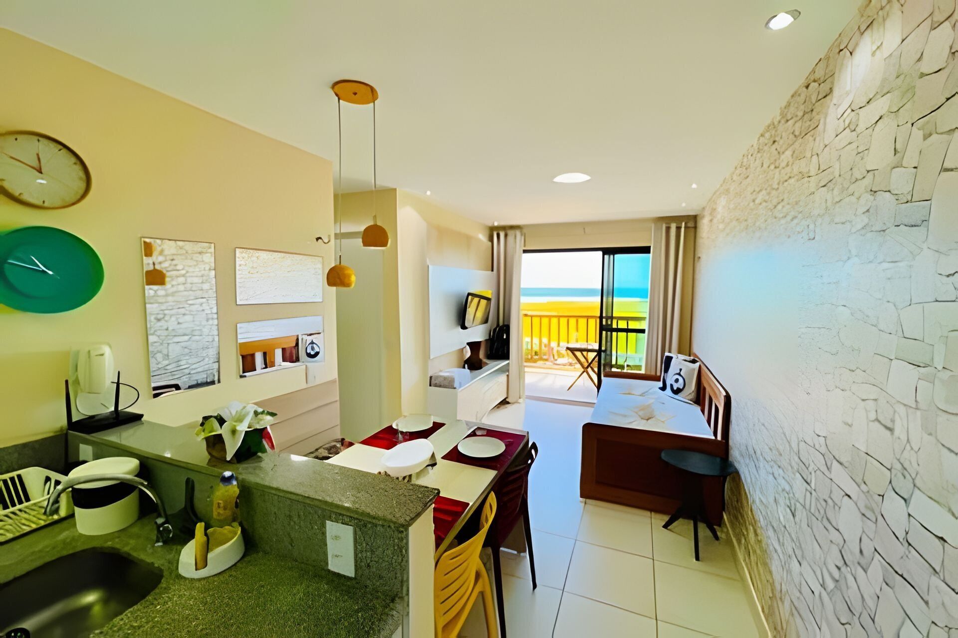 Ein modernes Hotelzimmer mit Küche, Essbereich und einem Balkon mit Blick.