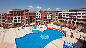 Relax by the central pool surrounded by lounge chairs and umbrellas.