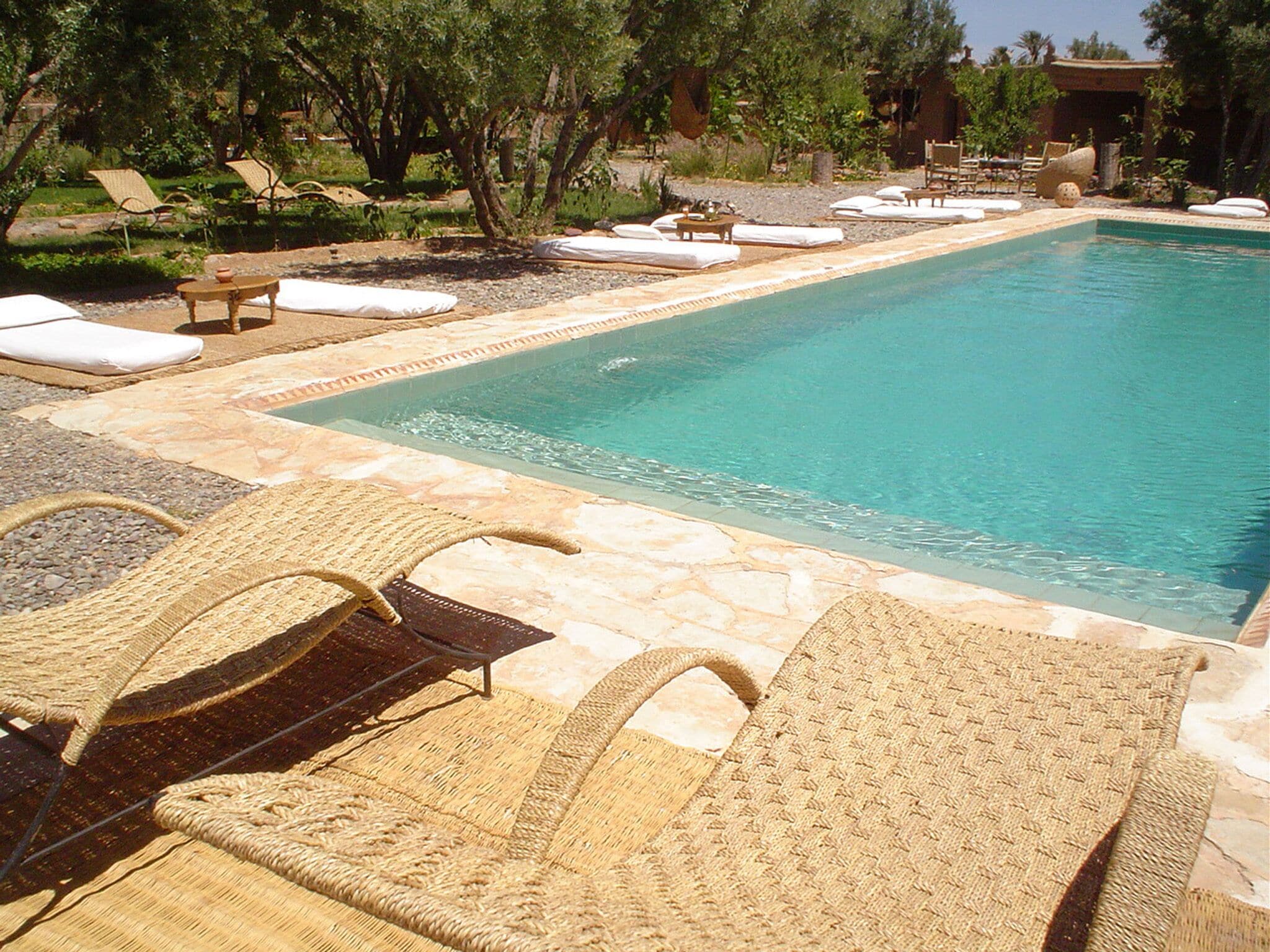 A pool area with lounge chairs and a stone deck.