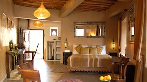Una habitación amplia con una cama grande, muebles de madera y un comedor.