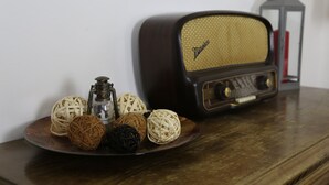 A vintage radio, a lantern, and decorative balls on a wooden table. - Tourist House Santa Croce (Florence)