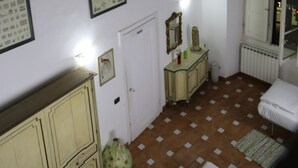 A room with a tiled floor, a white radiator, a door, a cabinet, and a window with a view. - Tourist House Santa Croce (Florence)