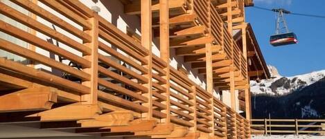 A building with a wooden facade, outdoor seating, and a mountain backdrop.