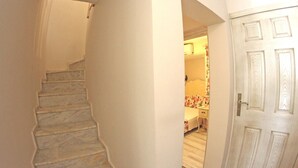 A staircase leading to a bedroom with a door and a mirror. - Stafilia Bozcaada - Adults Only (Bozcaada)