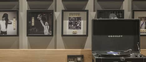 A wall with framed pictures and a record player on a table.